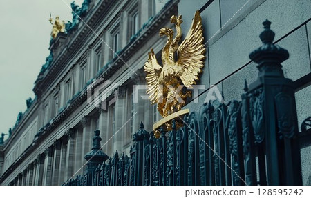 Gilded heraldic eagle emblem on a stately building facade, detailed view 128595242