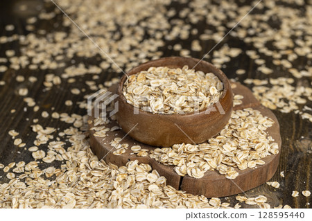 round bowl with oatmeal flakes for making porridge, close up round bowl with oatmeal flakes for making porridge, close up 128595440