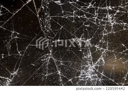 broken with a lot of damage of glass, thin glass broken into many pieces, close up 128595442