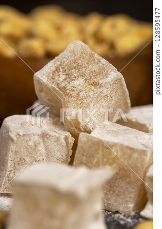 Turkish delight with peanuts closeup, scattered oriental sweets Turkish delight with peanuts on a slate board Turkish delight with peanuts closeup, scattered oriental sweets Turkish delight with peanuts on a slate board 128595477
