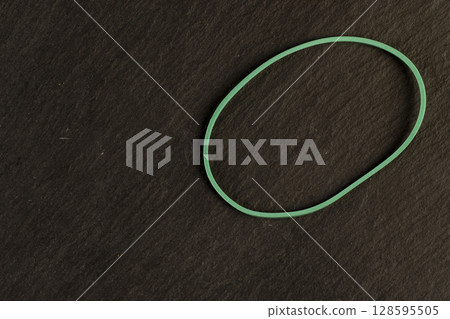 one multi-colored rubber band for office or money packaging, empty scattered thin rubber bands of different colors for packaging and organizing paper money 128595505