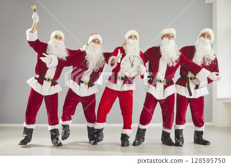 Happy New Year cute group dancing with clocks, partying wearing Santa Claus holiday costume Happy New Year cute group dancing with clocks, partying wearing Santa Claus holiday costume 128595750