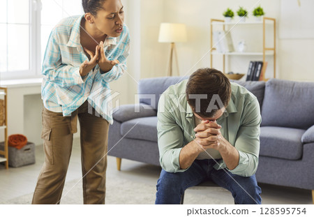 Angry african american wife shouting in quarrel on her unhappy upset husband at home. 128595754