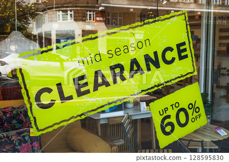 Bright yellow mid season clearance sale window sign advertising up to 60 percent off discounts Bright yellow mid season clearance sale window sign advertising up to 60 percent off discounts 128595830