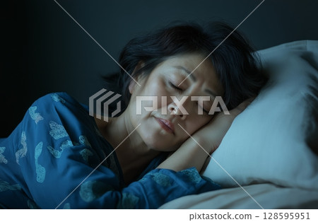 Woman Enjoying Peaceful Sleep in a Cozy Bedroom Environment During Nighttime Hours 128595951