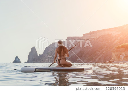 Woman Paddleboarding Ocean Coastline Relaxing Woman Paddleboarding Ocean Coastline Relaxing 128596013