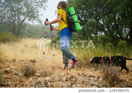 Hiker Exploring Rocky Terrain with Dog in Scenic Wilderness Setting 128596070