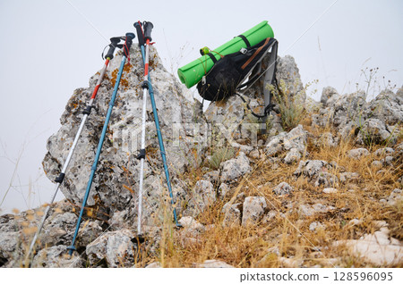 Hiking Gear and Trekking Poles on Rocky Terrain Outdoors 128596095