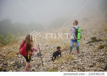 A Scenic Mountain Hike with Couple and Dog on a Misty Morning 128596138