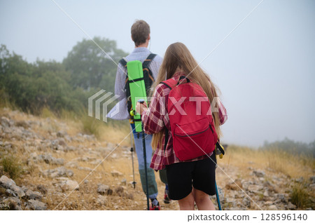 Two Hikers Enjoy Outdoor Adventure in a Scenic Mountain Landscape 128596140