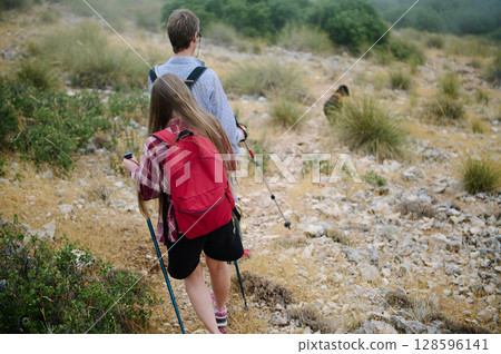 Hikers Trekking Through Rocky Terrain in a Natural Landscape 128596141