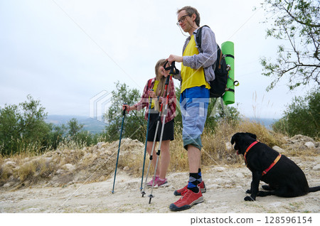 Couple Hiking With Their Dog on a Scenic Trail in Nature 128596154