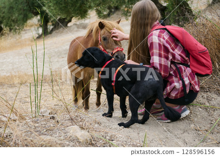 Person Hiking in Nature Interacting with Animals Among Hills and Vegetation 128596156
