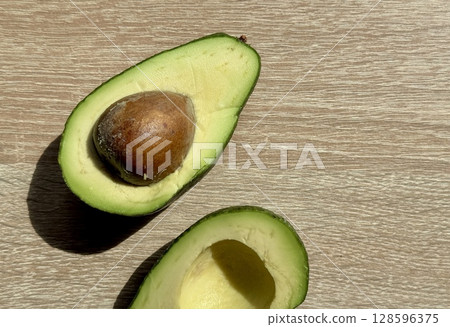 juicy ripe avocado cut in half on a monochrome background. High quality photo juicy ripe avocado cut in half on a monochrome background. High quality photo 128596375