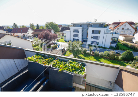 Charming residential house Real estate in Germany captured on a sunny summer day. garden, green lawn, and vibrant blue sky in the background Charming residential house Real estate in Germany captured on a sunny summer day. garden, green lawn, and vibrant blue sky in the background 128596747