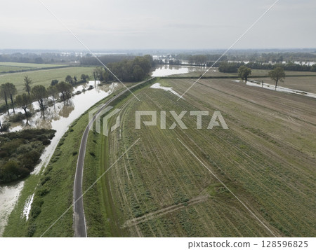 Flooded farmlands by the river swollen bursting it banks creating disasters for farmers, Italy 128596825
