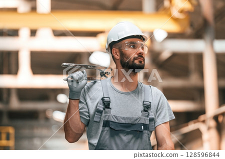 Handsome man. Young factory worker in grey uniform Handsome man. Young factory worker in grey uniform 128596844