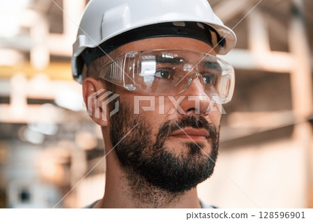 Beautiful portrait. Young factory worker in grey uniform 128596901