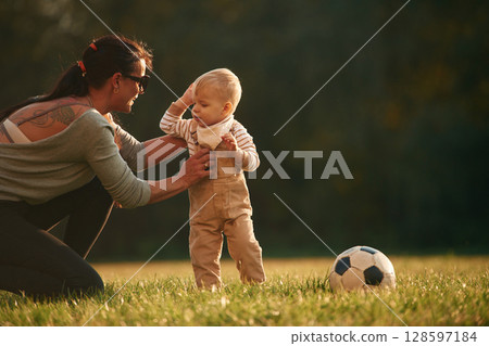 On the field. Mother is with her little baby son are outdoors together 128597184