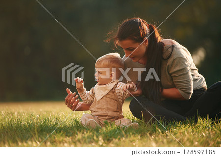 On the field. Mother is with her little baby son are outdoors together 128597185