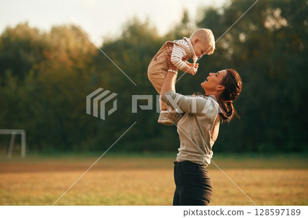 Holding kid in hands. Mother is with her little baby son are outdoors together 128597189