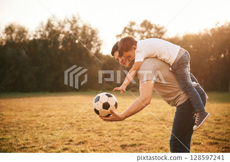 Soccer ball in hands. Father and little son are playing and having fun outdoors 128597241