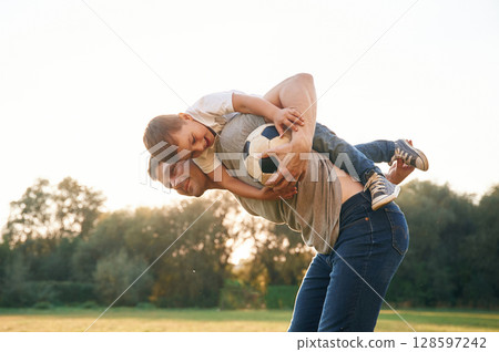 Soccer ball in hands. Father and little son are playing and having fun outdoors 128597242