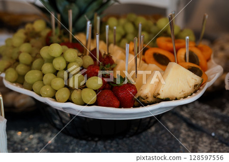 Vibrant Fruit Platter Display with Strawberries, Grapes, Pineapple, and Oranges for a Healthy Dessert. Refreshing Food Presentation. 128597556