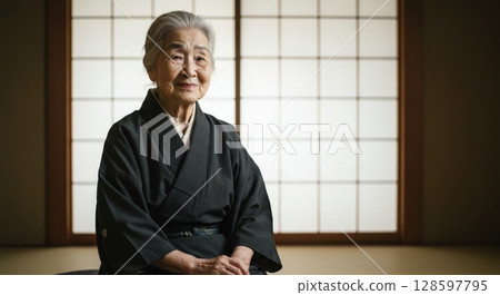 Elegant portrait of a senior japanese woman in black kimono sitting in a traditional room Elegant portrait of a senior japanese woman in black kimono sitting in a traditional room 128597795