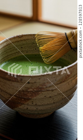 Japanese matcha green tea preparation with a traditional bamboo whisk in a ceramic chawan bowl Japanese matcha green tea preparation with a traditional bamboo whisk in a ceramic chawan bowl 128597813