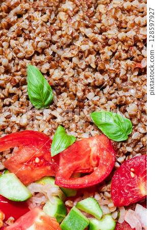 Healthy food without meat with buckwheat and a salad of chopped tomatoes, cucumbers, onions and basil leaves. The photo is suitable for the topic of healthy lifestyle and healthy eating Healthy food without meat with buckwheat and a salad of chopped tomatoes, cucumbers, onions and basil leaves. The photo is suitable for the topic of healthy lifestyle and healthy eating 128597927