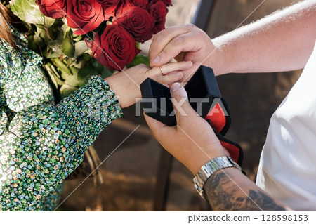 Romantic Marriage Proposal with Red Roses: Man Proposing to Woman with Diamond Ring Outdoors, Love, Commitment, Engagement, Relationship Goals. Romantic Marriage Proposal with Red Roses: Man Proposing to Woman with Diamond Ring Outdoors, Love, Commitment, Engagement, Relationship Goals. 128598153