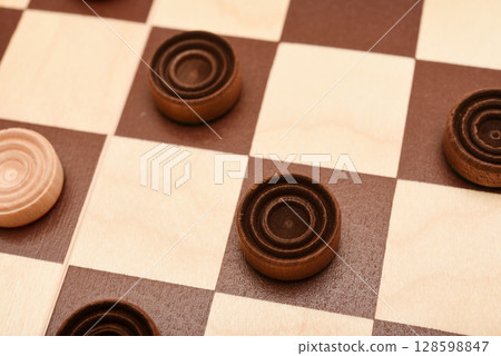Wooden checkers on the board. The board game checkers. 128598847