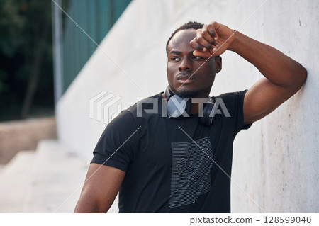 Posing and standing. Handsome black man is outdoors at daytime Posing and standing. Handsome black man is outdoors at daytime 128599040