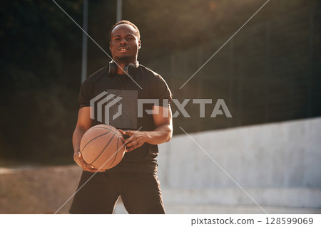 Photo in motion. Young black man is with basketball ball outdoors Photo in motion. Young black man is with basketball ball outdoors 128599069