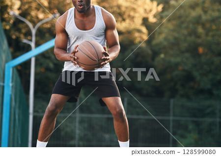 Front view. Young black man is with basketball ball outdoors 128599080