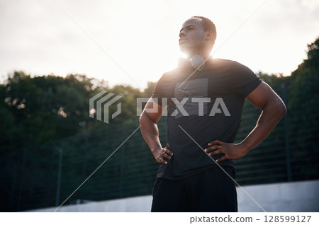Beautiful sunlight. Handsome black man is posing outdoors at daytime 128599127