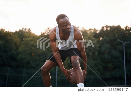 Playing the game. Young black man is with basketball ball outdoors Playing the game. Young black man is with basketball ball outdoors 128599147