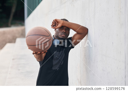 Holding ball in hands. Young black man 128599176