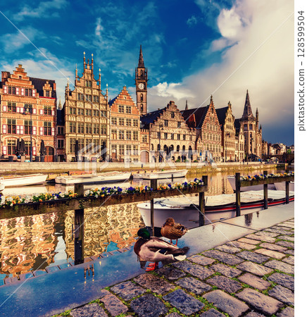 Ghent city historical center, tourists boats and colorful buildings on Leie river bank, Belgium 128599504