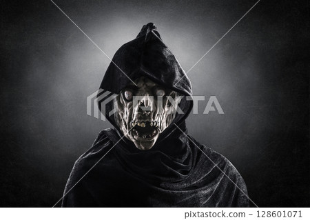 Portrait of a zombie with hooded cape over dark misty background 128601071