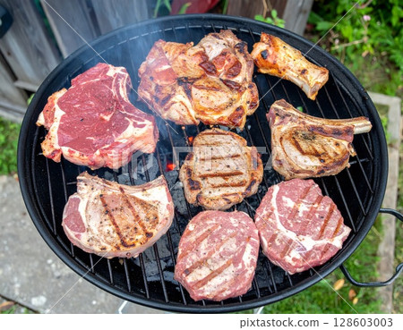 Juicy barbecue meat on the grill, close view, summer barbecue bliss background 128603003