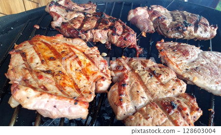 Juicy barbecue meat on the grill, close view, summer barbecue bliss background 128603004