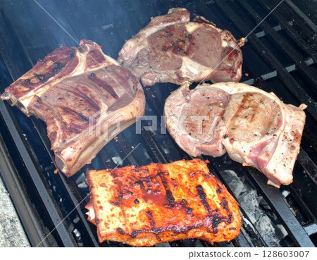 Juicy barbecue meat on the grill, close view, summer barbecue bliss background 128603007