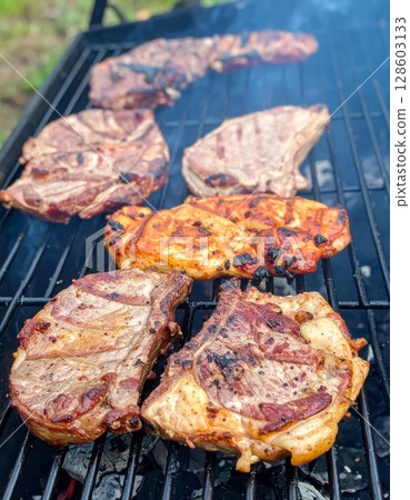Juicy barbecue meat on the grill, close view, summer barbecue bliss background 128603133