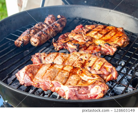 Juicy barbecue meat on the grill, close view, summer barbecue bliss background 128603149