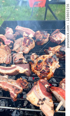 Juicy barbecue meat on the grill, close view, summer barbecue bliss background 128603156