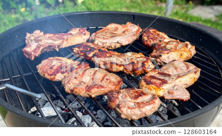Juicy barbecue meat on the grill, close view, summer barbecue bliss background 128603164