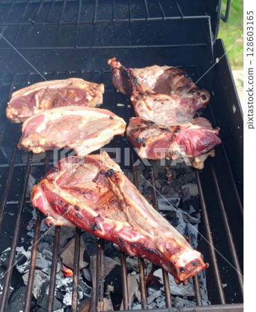 Juicy barbecue meat on the grill, close view, summer barbecue bliss background 128603165