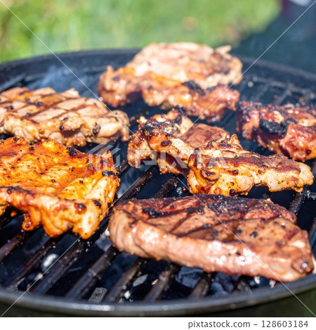 Juicy barbecue meat on the grill, close view, summer barbecue bliss background 128603184